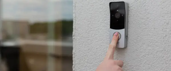 Videoportero con cámara instalado junto a una puerta de acceso