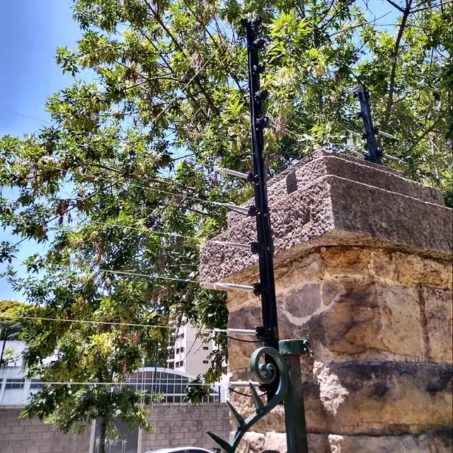 Cerco eléctrico de seis hilos instalado sobre un muro de piedra en CABA