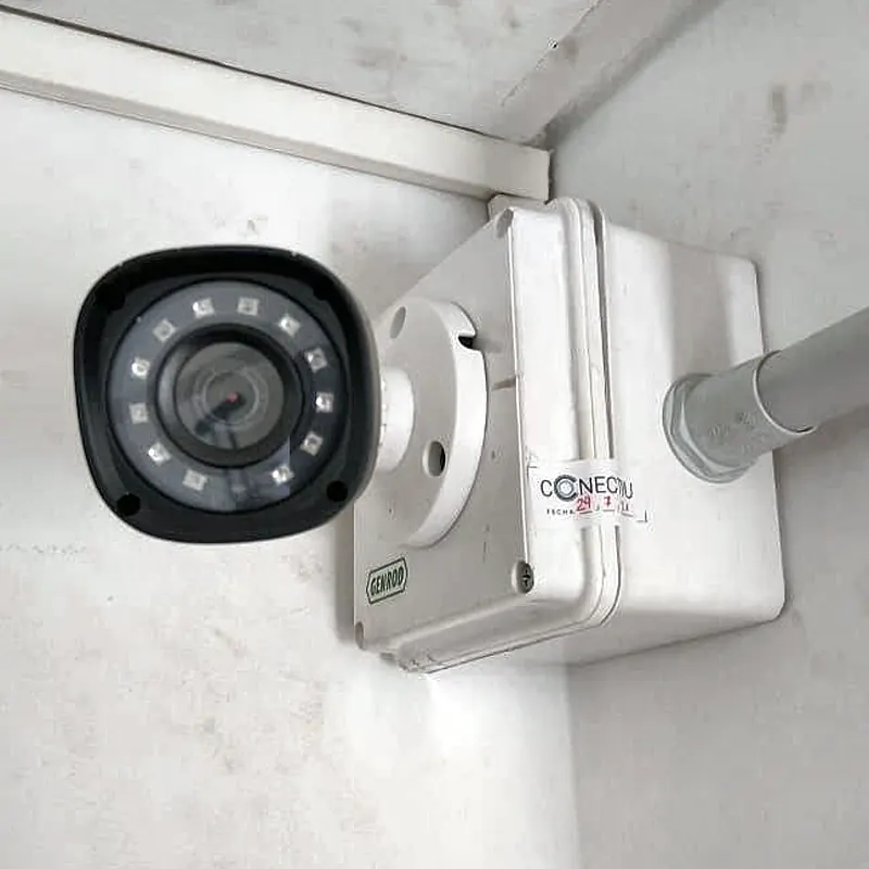 Cámara de seguridad con caja de conexión en el palier de una oficina en CABA
