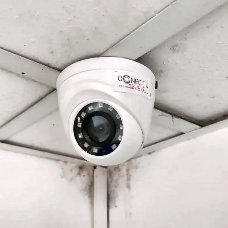 Cámara domo con etiqueta de Conectiu instalada en el techo de una empresa