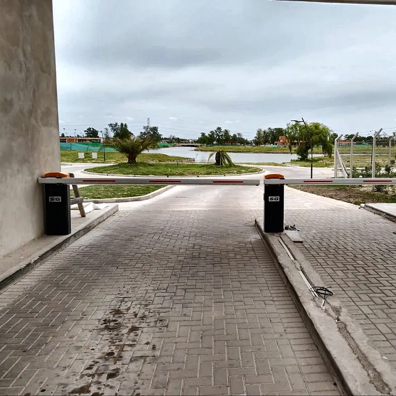Dos barreras vehiculares automáticas, una de ingreso y otra de egreso, en la entrada de un barrio cerrado de Escobar